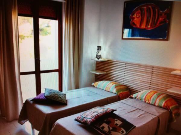 a bedroom with two beds and a window at B&B Torre Pelosa in Torre a Mare