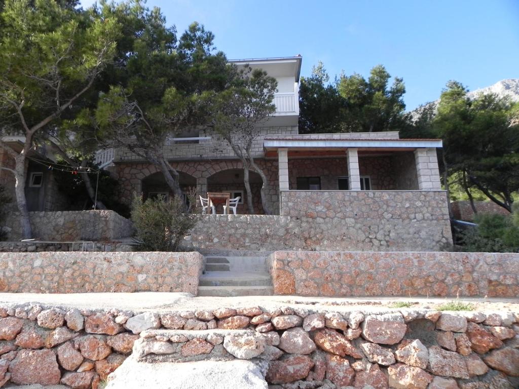 a house with a stone wall in front of it at Apartment Sveta Nedilja 11433a in Jelsa