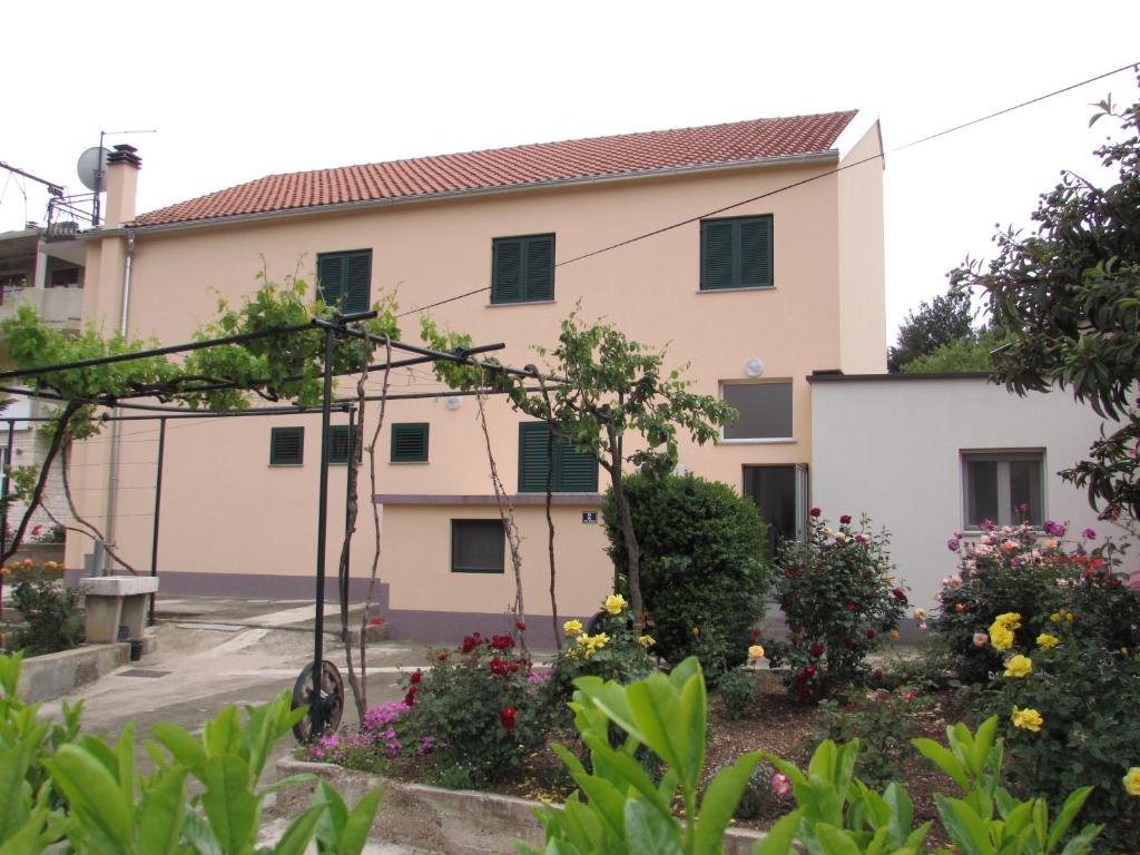 ein Gebäude mit einem Garten davor in der Unterkunft Rooms with a parking space Sibenik - 13739 in Šibenik