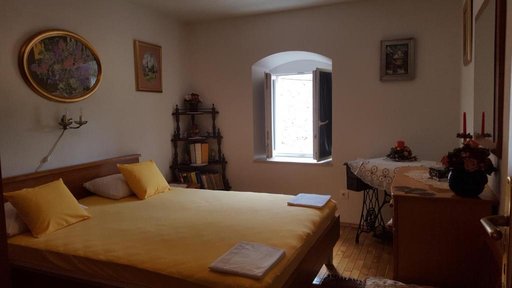 a bedroom with a bed and a table and a window at Apartments with a parking space Jelsa, Hvar - 13759 in Jelsa
