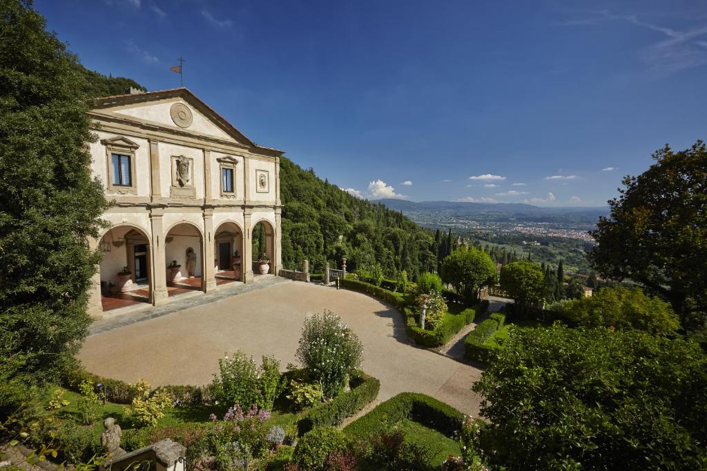 een oud huis met een tuin ervoor bij Villa San Michele, A Belmond Hotel, Florence in Fiesole