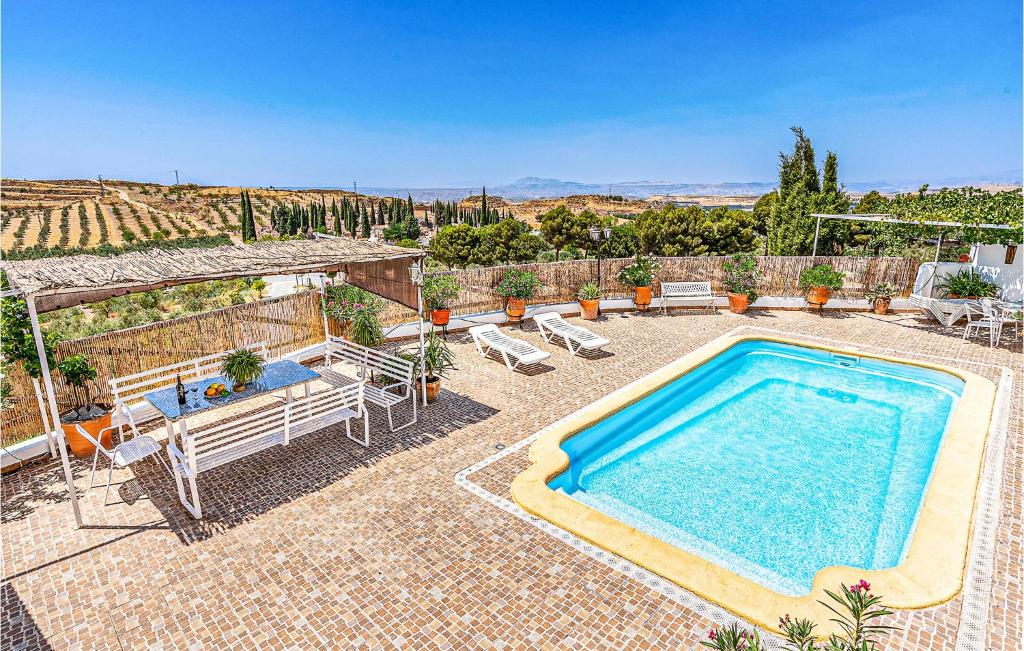 a swimming pool in a yard with chairs at Stunning Home In Cuevas Del Campo With House A Mountain View in Cuevas del Campo
