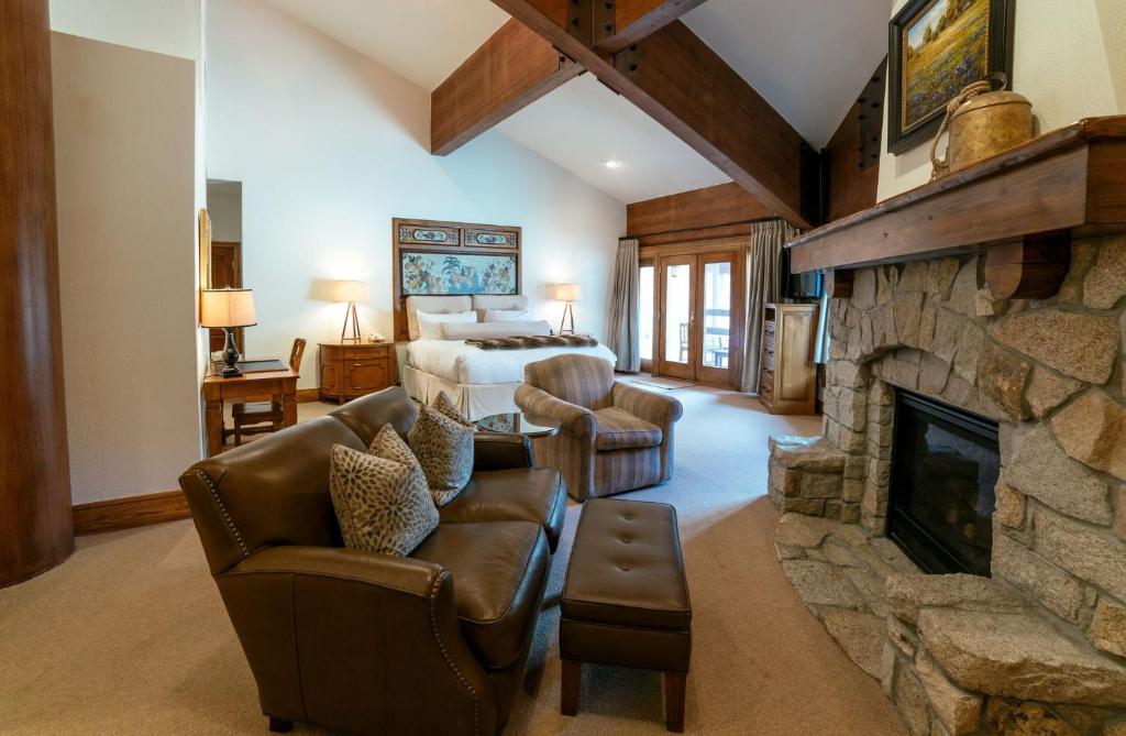 a living room with a stone fireplace and a bedroom at Luxury King Room Hotel Room in Park City