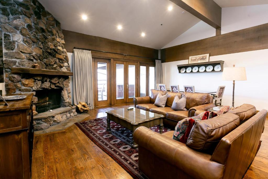 a living room with leather furniture and a stone fireplace at Bald Eagle Two Bedroom apartment hotel in Park City