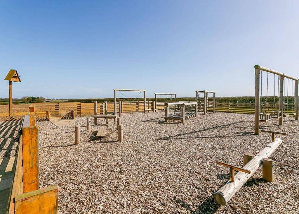 an empty playground with a bunch of swings at Fairview Lodges in Withernsea