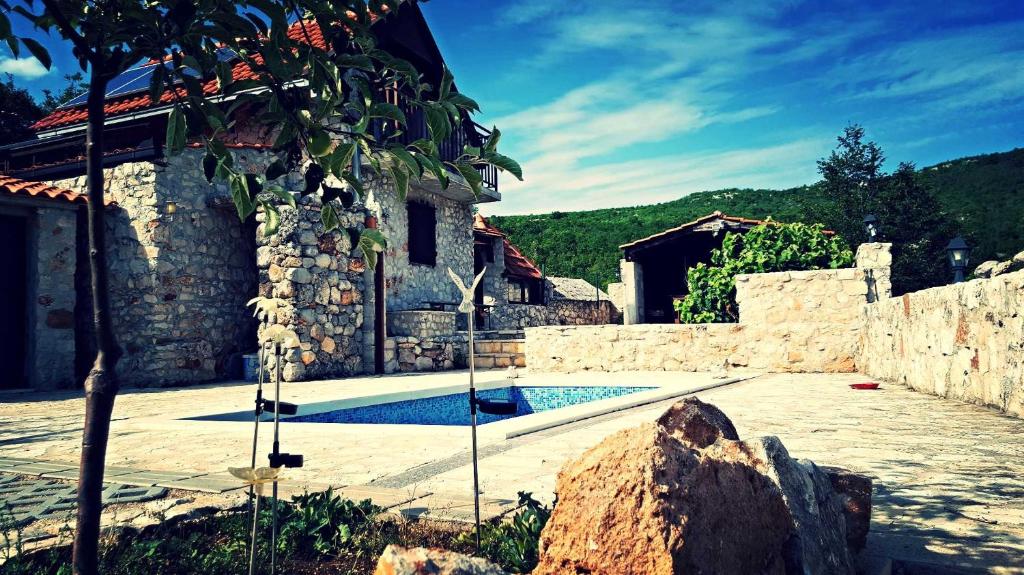 ein Steinhaus mit einem Pool im Hof in der Unterkunft Family friendly house with a swimming pool Zagvozd, Zagora - 13901 in Zagvozd