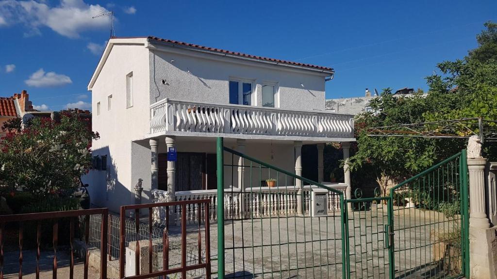 a white house with a fence in front of it at Apartments with a parking space Rudina, Hvar - 13903 in Stari Grad
