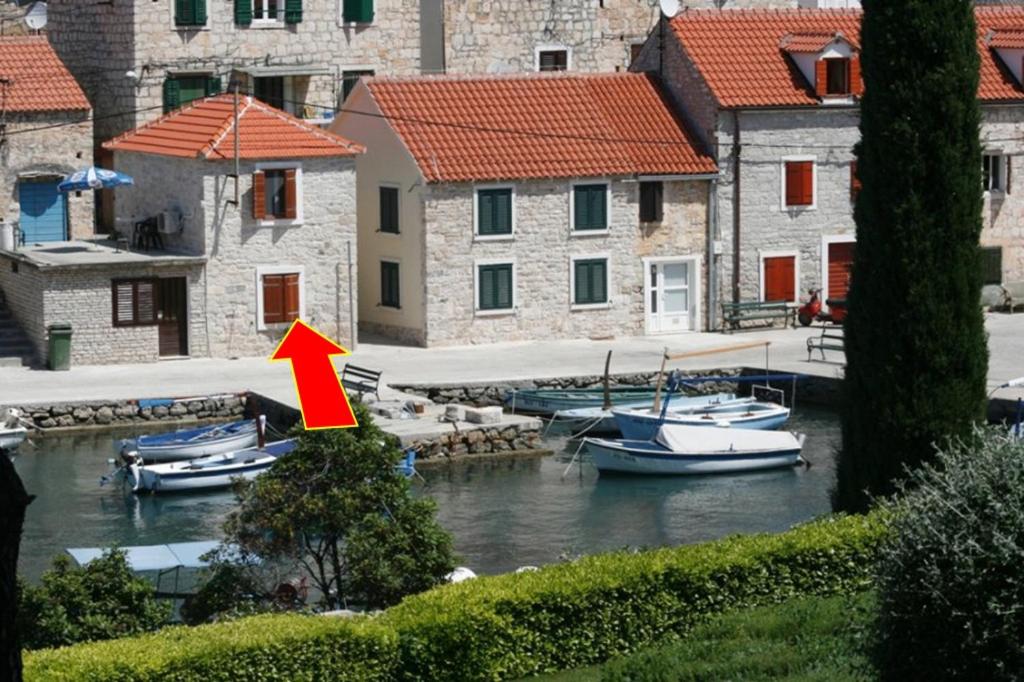 a group of boats in a marina with a red arrow at Seaside holiday house Maslinica, Solta - 13965 in Grohote