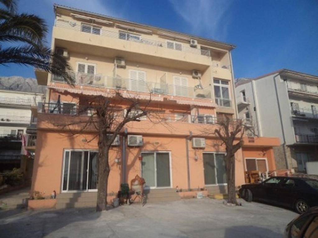 a building with a car parked in front of it at Apartments and rooms with parking space Makarska - 13979 in Makarska