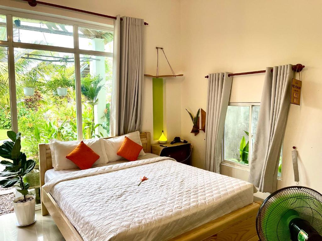 a bedroom with a bed and a large window at BinhYen Homestay in Mui Ne