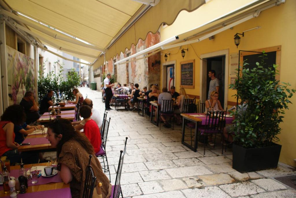扎達爾的住宿－Apartments and rooms with WiFi Zadar - 14030，一群坐在餐厅桌子上的人