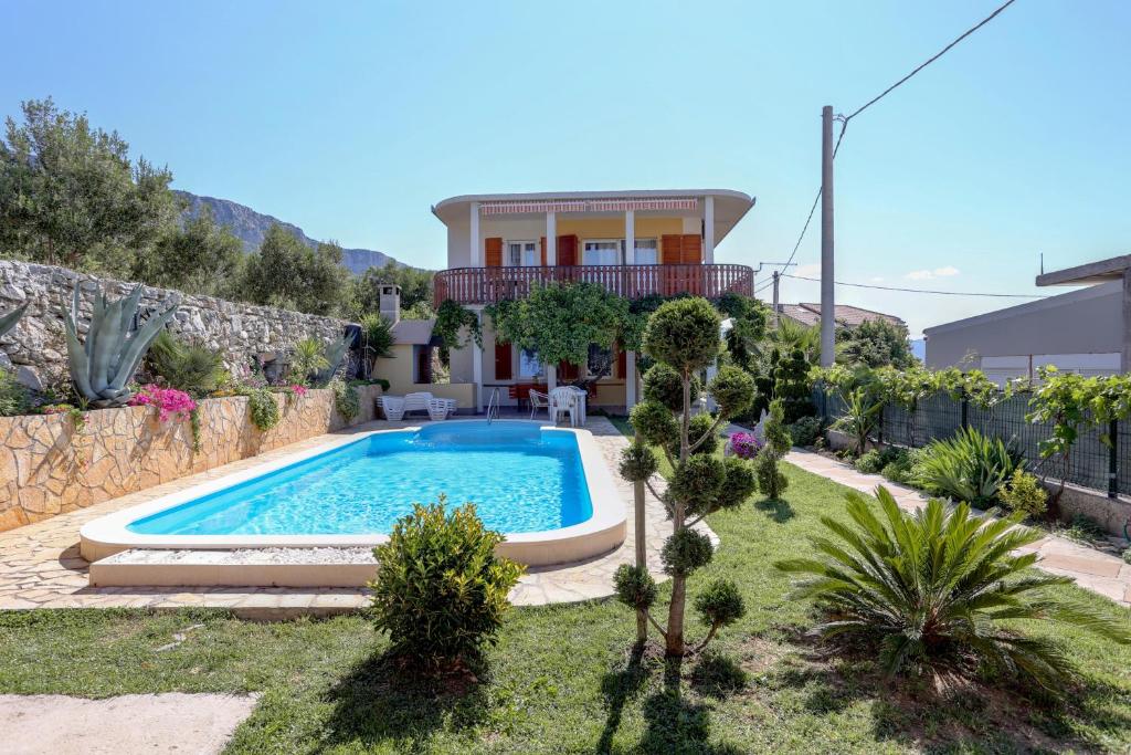 a villa with a swimming pool in front of a house at Family friendly apartments with a swimming pool Kastel Sucurac, Kastela - 14047 in Kaštela