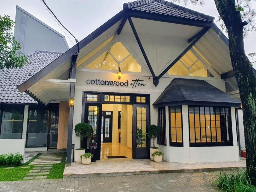 una tienda frente a un edificio con una puerta amarilla en Cottonwood Boutique Heritage Otten en Bandung