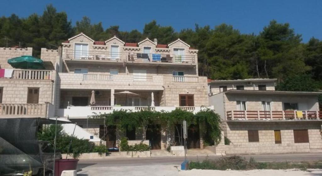 a large brick building with balconies on top of it at Apartments by the sea Povlja, Brac - 14126 in Povlja