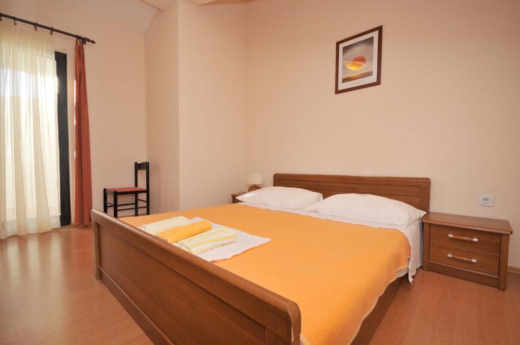 sypialnia z dużym pomarańczowym łóżkiem w pokoju w obiekcie Apartments with a parking space Okrug Donji, Ciovo - 13732 w mieście Okrug Donji