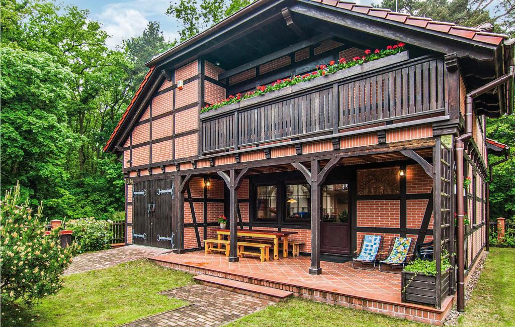 a house with a deck with a table and chairs at Awesome Home In Pobierowo With 4 Bedrooms in Pobierowo