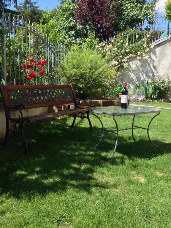 a bench and a table with a bottle of wine at Casa Lanze in Castagnole Lanze
