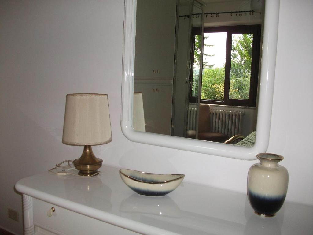 una lámpara y un tazón sobre una mesa con un espejo en Casa Lanze, en Castagnole Lanze