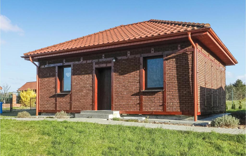 a small brick house with a red roof at Cozy Home In Glowczyce With Sauna in Główczyce