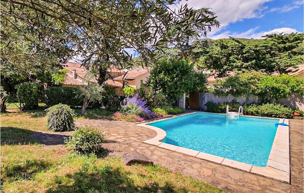 a swimming pool in a yard next to a house at Nice Home In Berlou With Wifi, Private Swimming Pool And 3 Bedrooms in Berlou