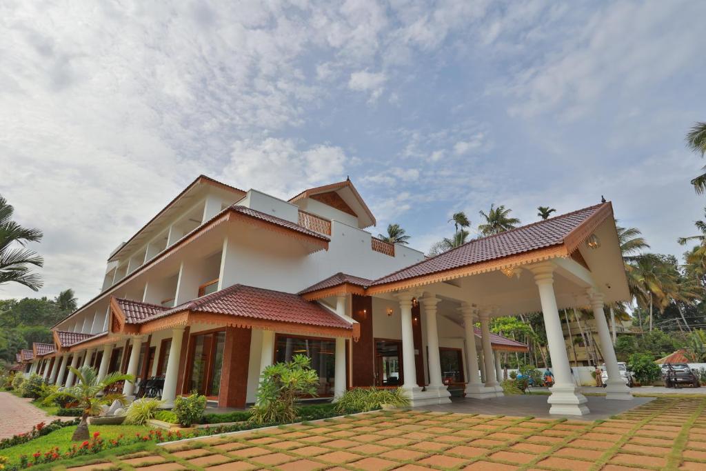 a large white building with a lot of columns at Lagoona Beach Resort in Kovalam