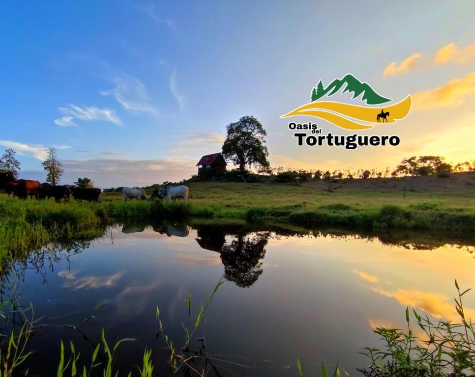 una señal para un campo con ganado y un río en Oasis del Tortuguero en Cariari