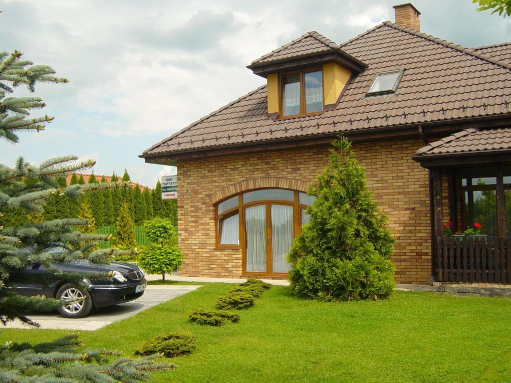 a house with a car parked in front of it at Dom Turysty Na Skarpie in Malbork