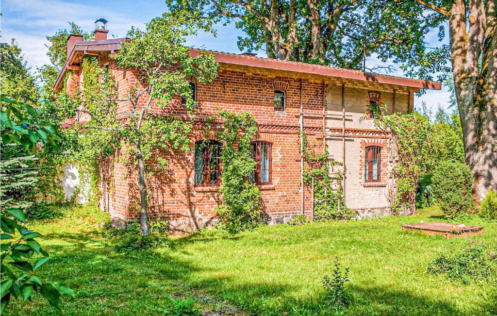 an old brick house sitting in the middle of a yard at Cozy Home In Sasino With Kitchen in Sasino