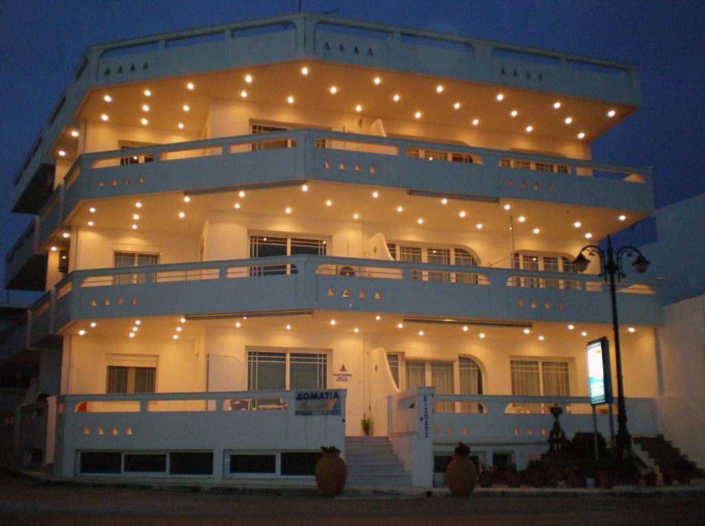 un gran edificio blanco con luces encendidas por la noche en Neapoli Rooms, en Neápolis