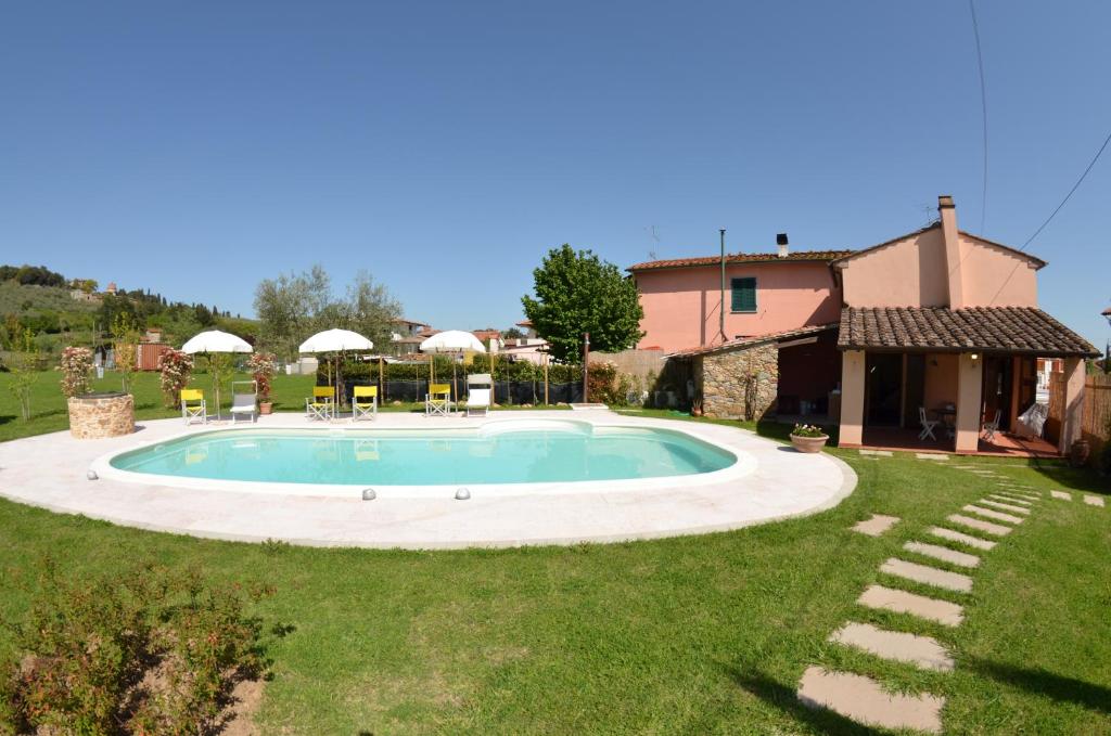 a swimming pool in a yard next to a house at Al Vecchio Pozzo in Buti