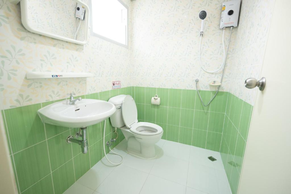 La salle de bains est pourvue de toilettes et d'un lavabo. dans l'établissement หรรษาเพลส ลาดพร้าว 124, à Ban Bang Toei (1)