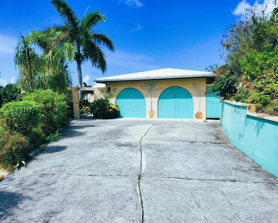 a house with two blue garage doors on a driveway at The View in Christiansted