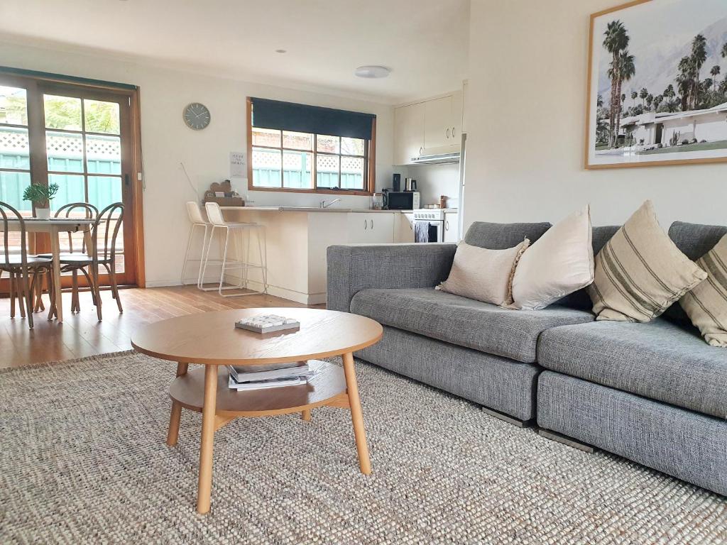 uma sala de estar com um sofá e uma mesa em Olive Street Apartment em Albury