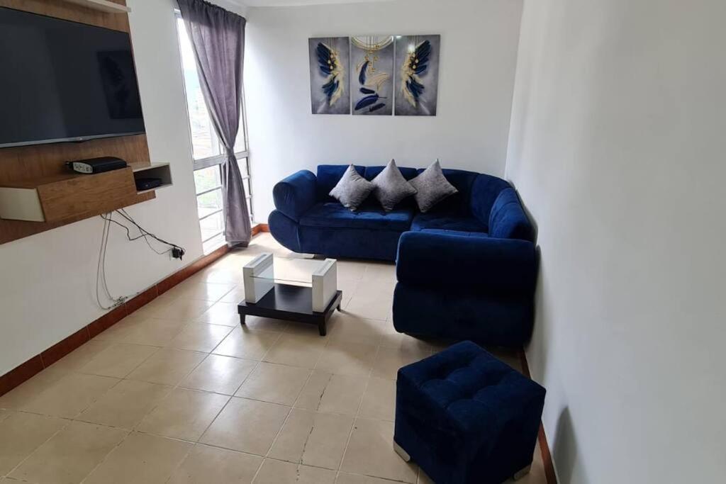 a living room with a blue couch and a tv at Hermoso Apartamento en excelente ubicación. in Medellín