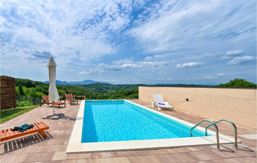 einen Pool mit Terrasse und Sonnenschirm in der Unterkunft Amazing Home In Beretinec With Sauna in Beretinec
