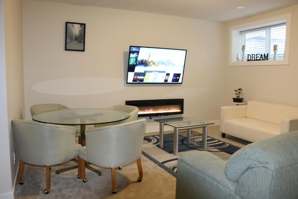 a living room with a table and a couch and a tv at Guest Suite in Calgary in Calgary