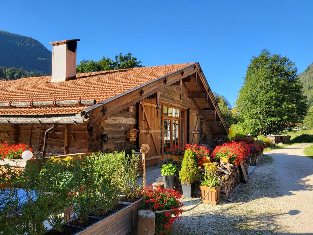 ein Holzhaus mit Blumen davor in der Unterkunft Nickis Bergcamp in Schneizlreuth
