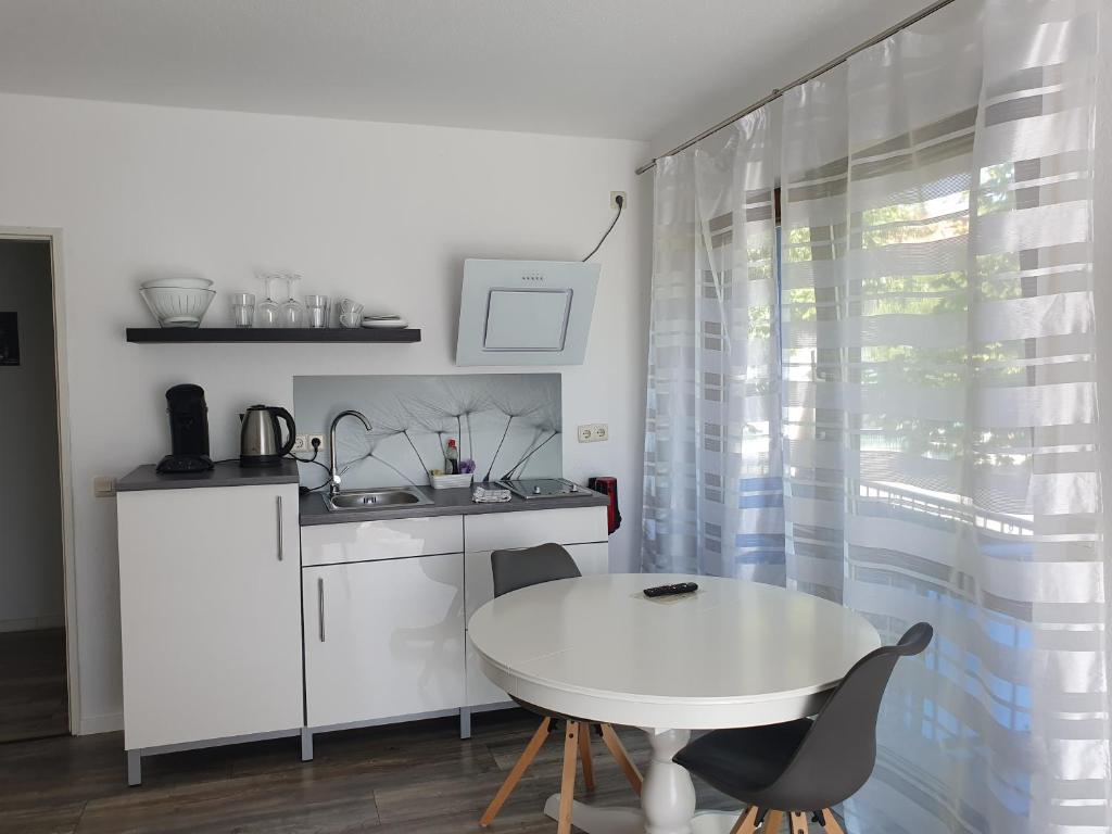 a small kitchen with a white table and a sink at City Apartment, 27 qm, 2 Personen, high Sp WLAN in Paderborn