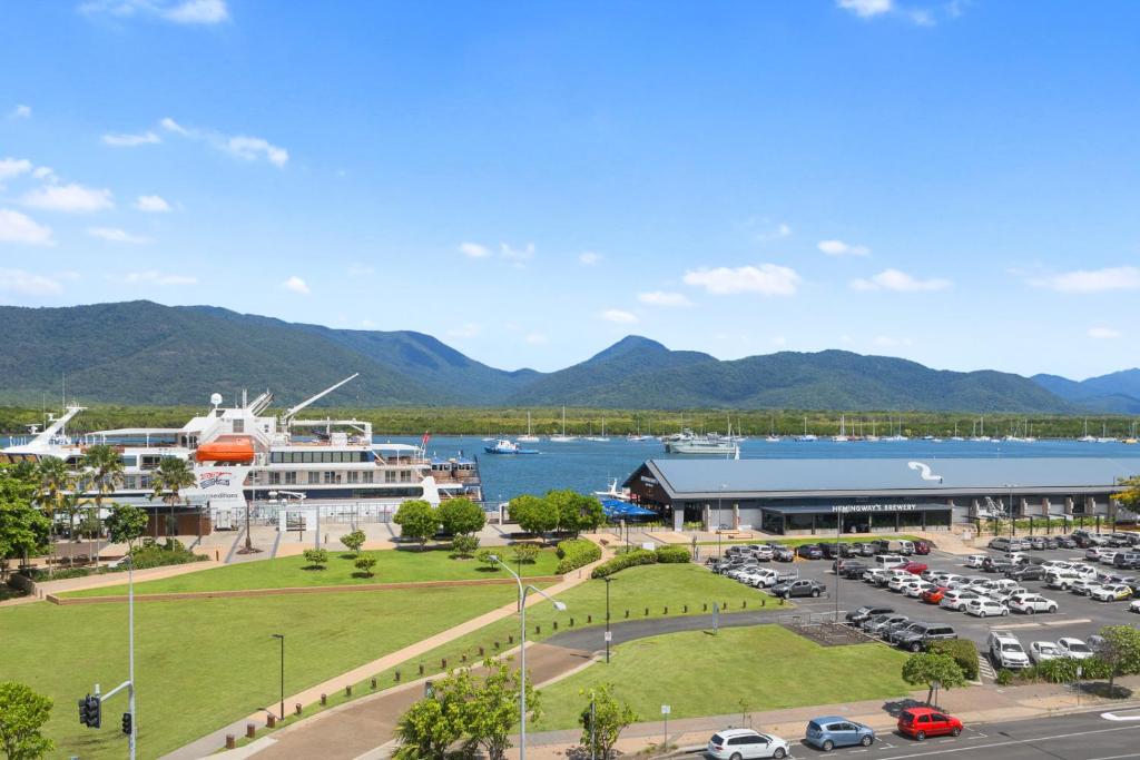 a parking lot in front of a harbor with a cruise ship at Stunning Coastal 3 Bedroom Apartment in Cairns CBD in Cairns