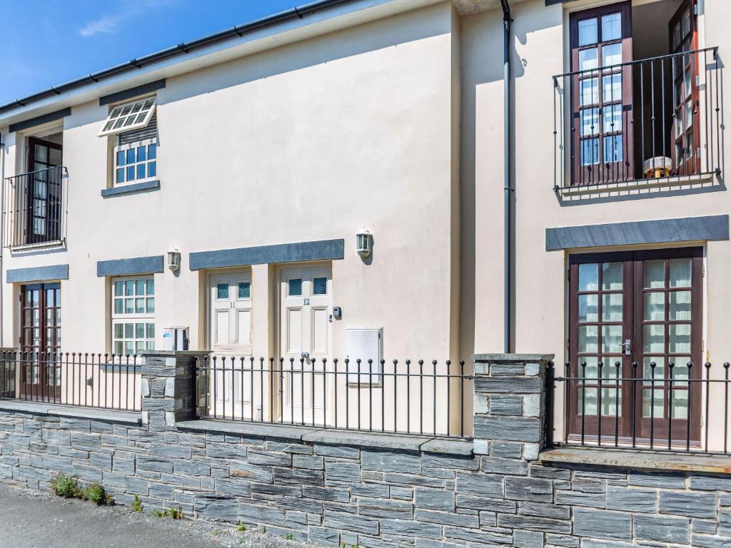 a white house with a stone wall at Harbour View in Porthmadog