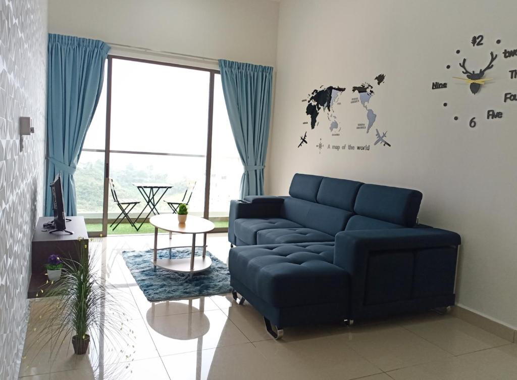 a living room with a blue couch and a clock on the wall at ComfyHome at Palas Horizon Residence with sunrise view in Brinchang