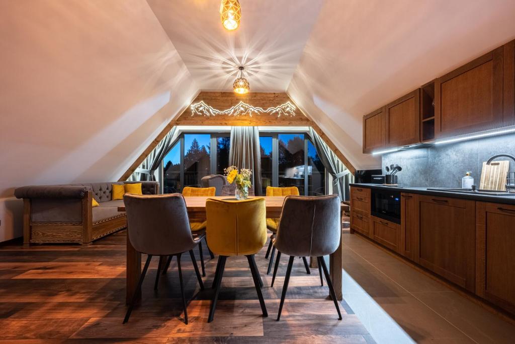 a kitchen with a table and chairs in a room at Apartamenty Polana pod Nosalem - zachód in Zakopane
