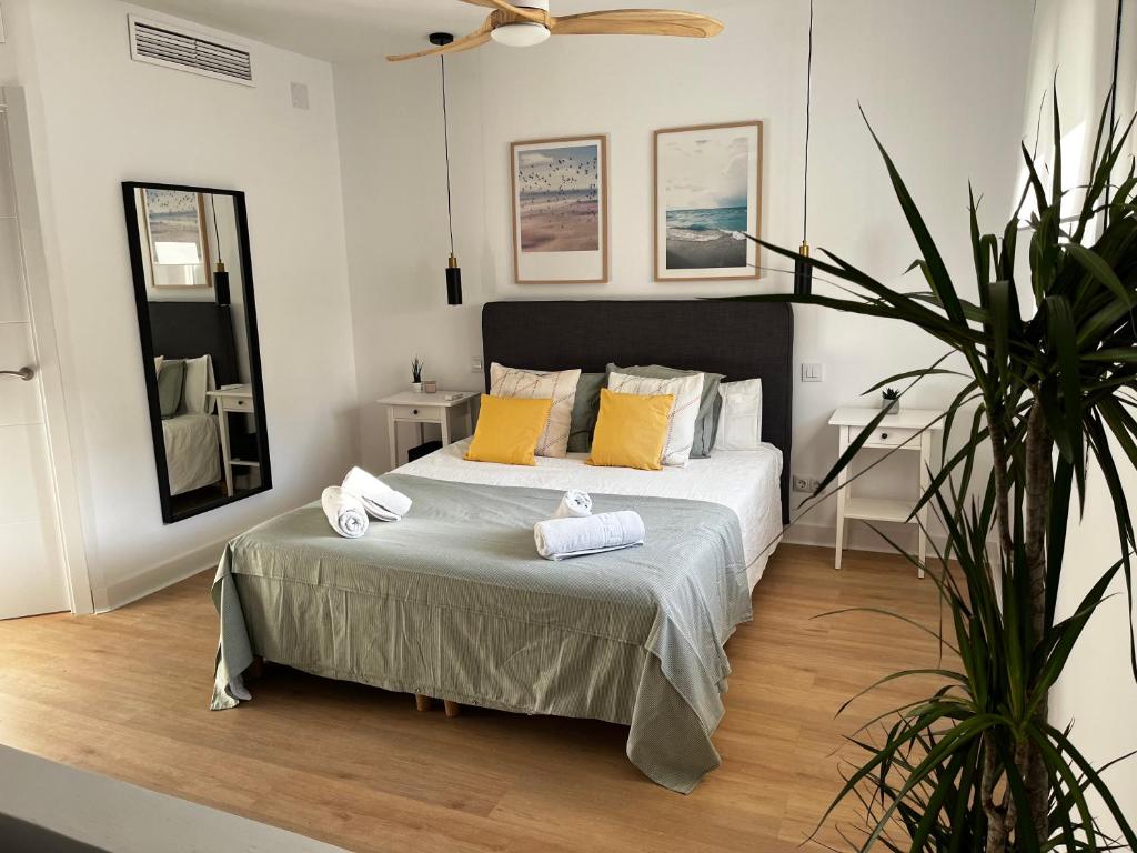 a bedroom with a bed with yellow pillows and a plant at Wonderful Loft, parking free V in Málaga