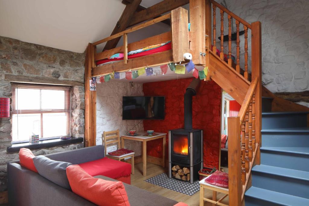 a living room with a loft bed and a fireplace at The Bake House in Llangennith