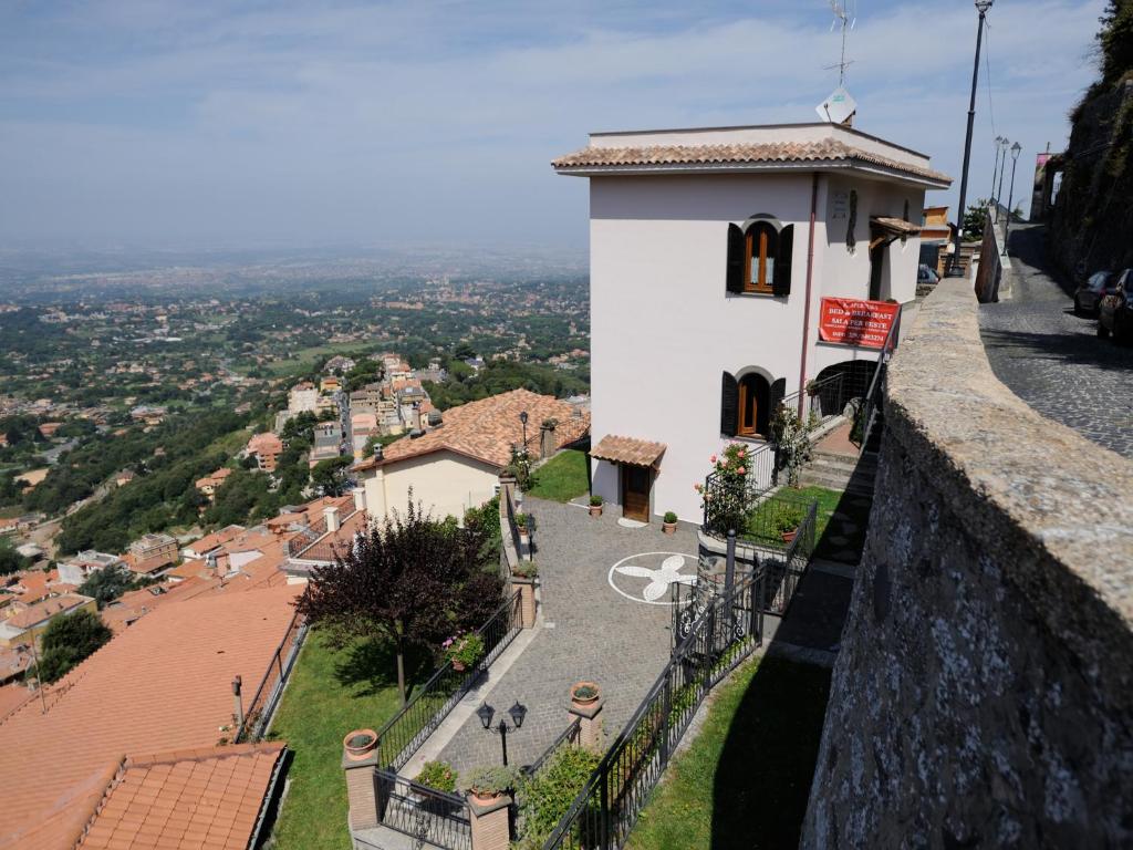 a building on a hill with a view of a town at Villa dei Fantasmi in Rocca di Papa