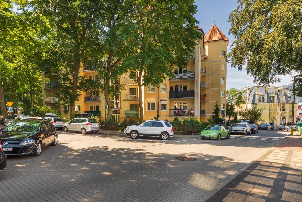 a parking lot with cars parked in front of a building at Apartamenty Pod Wieżyczkami by Renters in Międzyzdroje