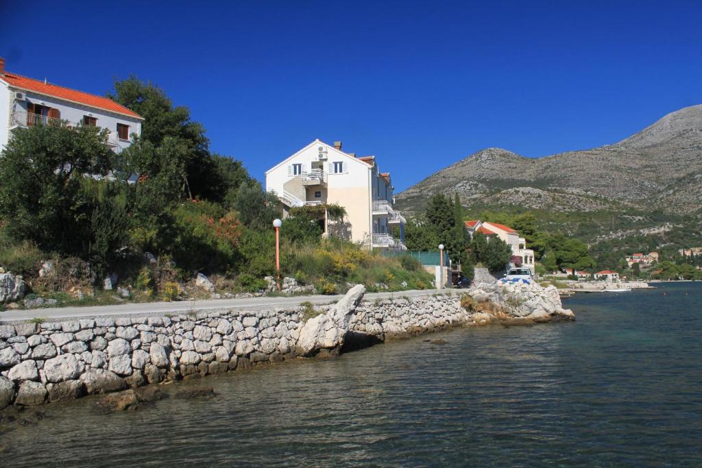 a group of buildings on the shore of a body of water at Apartments by the sea Slano, Dubrovnik - 8741 in Slano