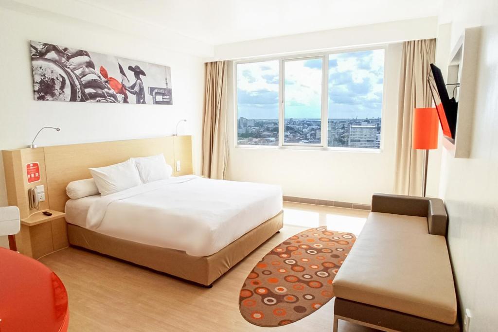 Postel nebo postele na pokoji v ubytování HARRIS Hotel Pontianak