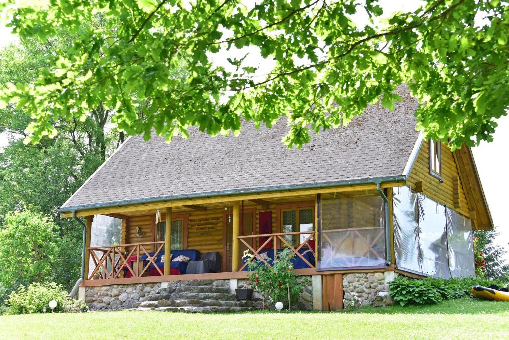 a log cabin with a porch and a deck at Sodyba “Rita” in Mėčiūnai