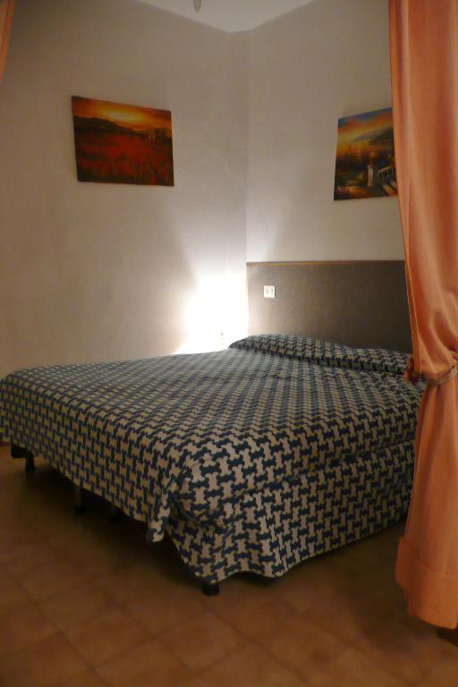 a bedroom with a bed with a black and white comforter at Hotel Ristorante Il Gabbiano in Cecina